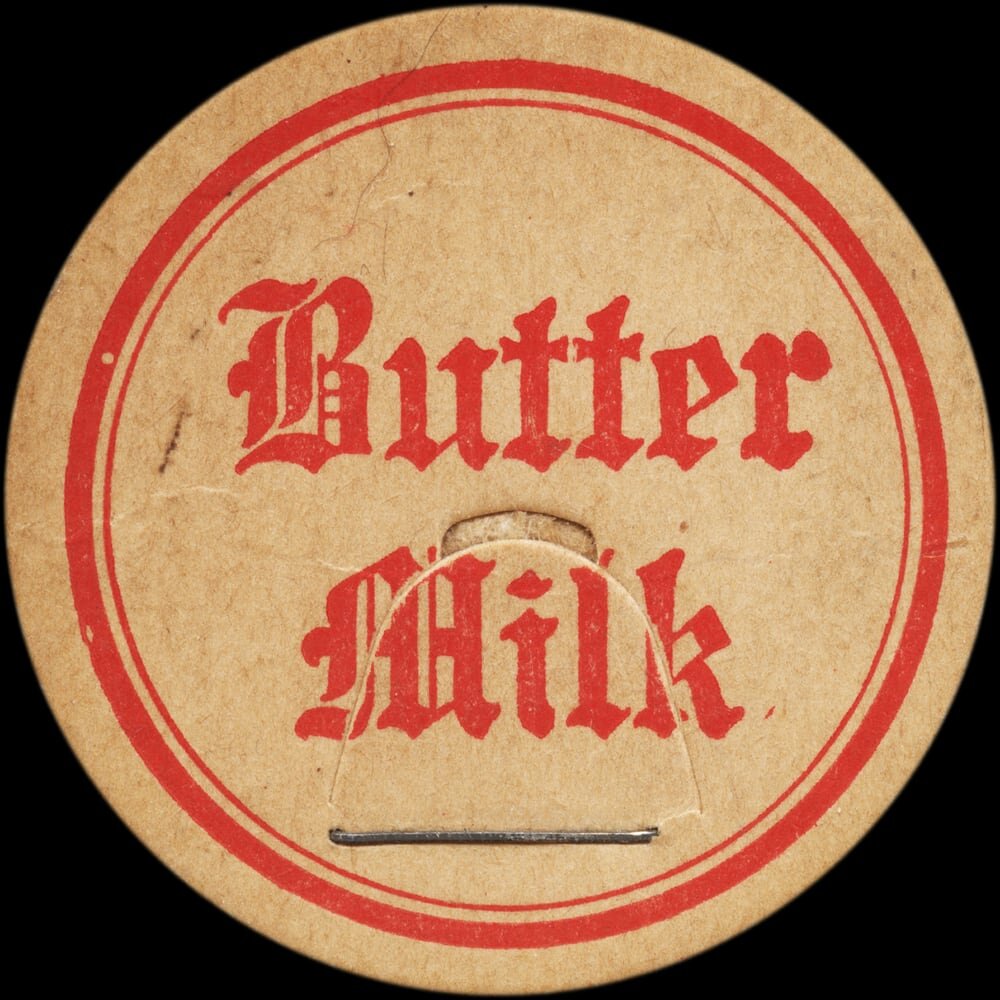 Vintage circular dairy cap with printed typographic milk advertising and a metal pull tab.