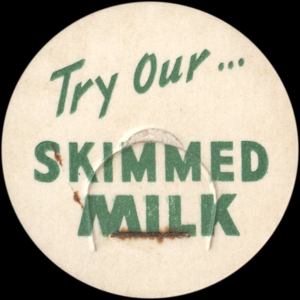 Vintage circular dairy cap with printed typographic milk advertising and a metal pull tab.