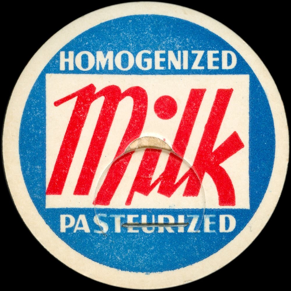 Vintage circular dairy cap with printed typographic milk advertising and a metal pull tab.