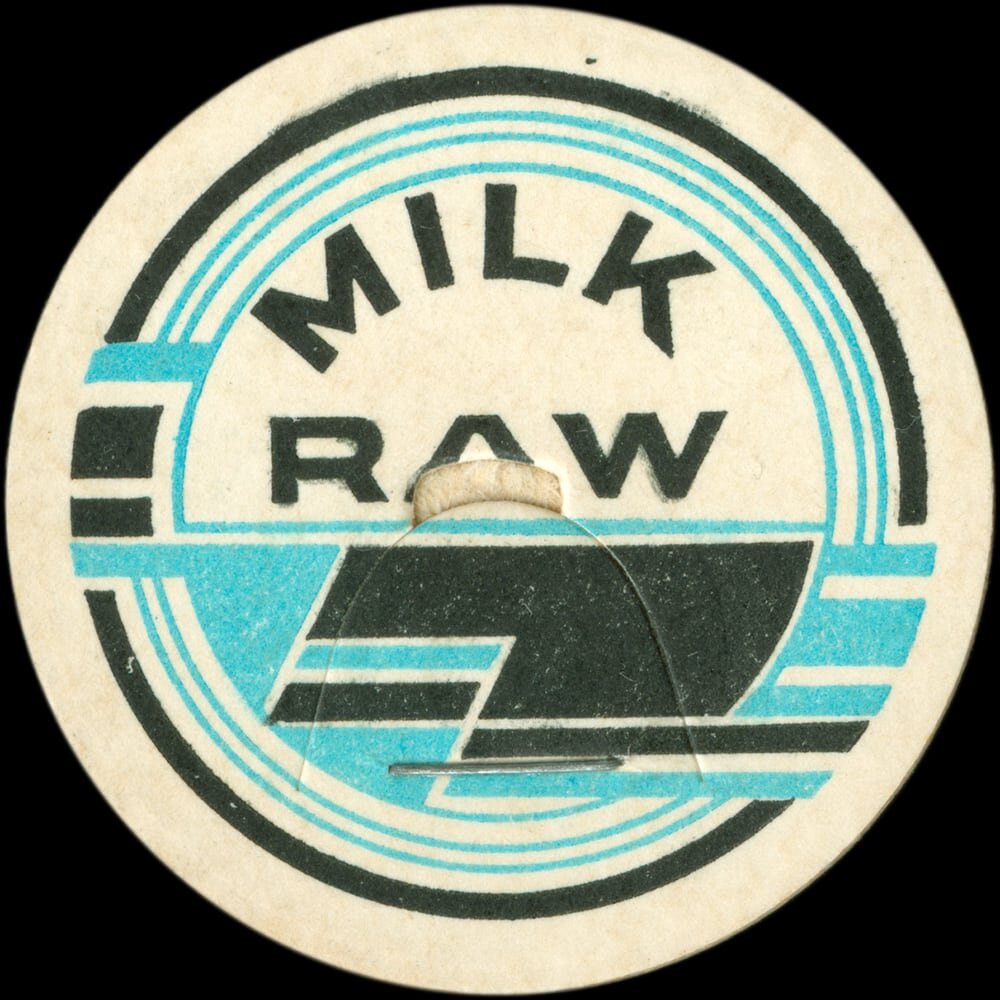 Vintage circular dairy cap with printed typographic milk advertising and a metal pull tab.