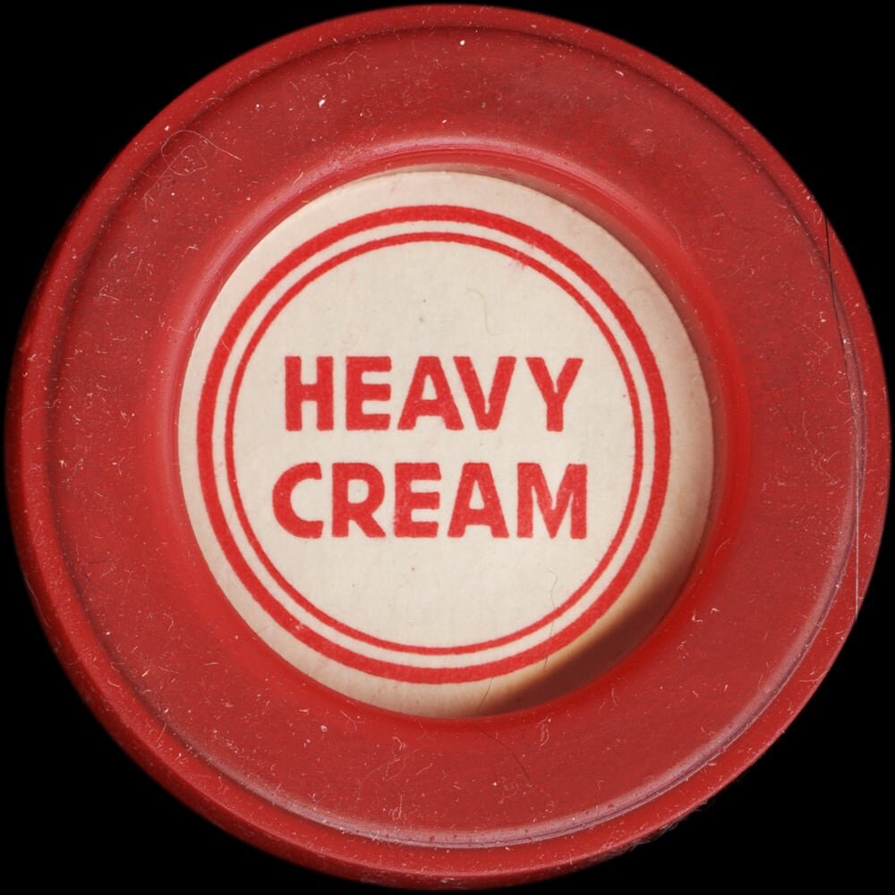 Vintage circular dairy cap with printed typographic milk advertising and a metal pull tab.