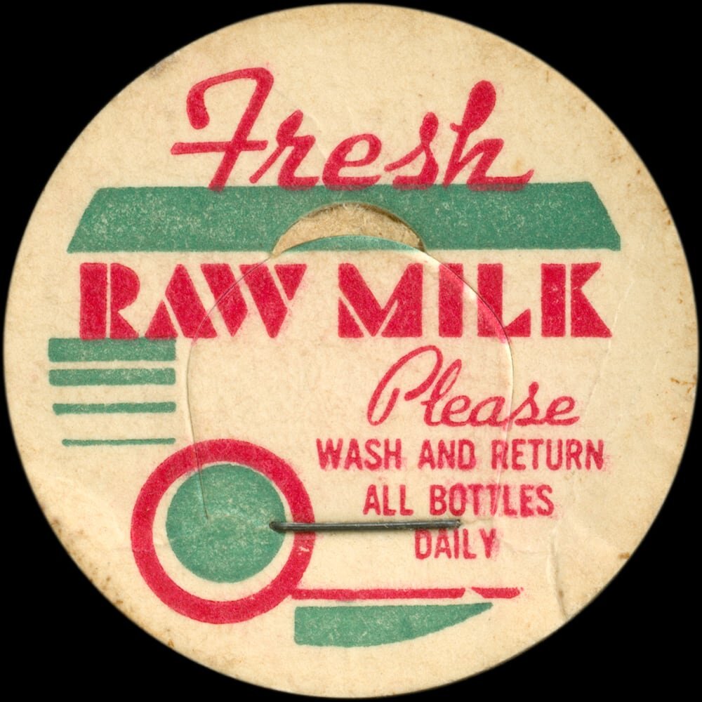 Vintage circular dairy cap with printed typographic milk advertising and a metal pull tab.