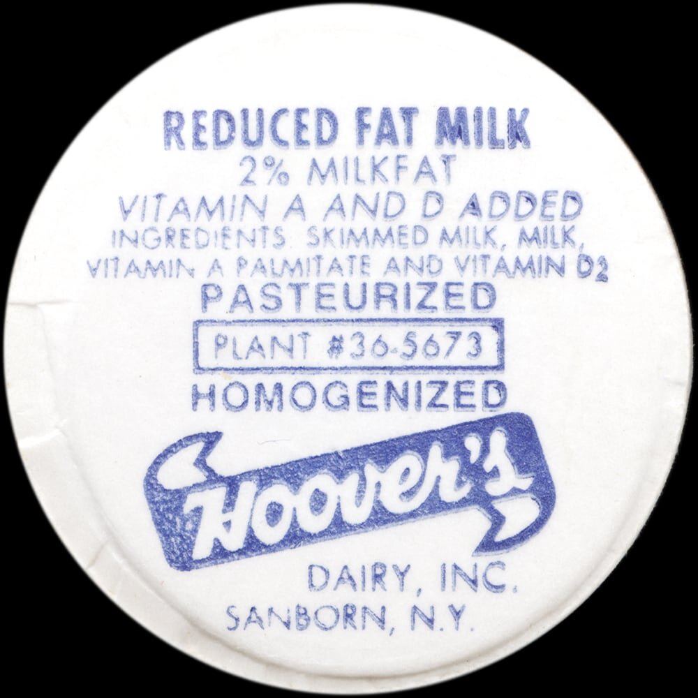Vintage circular dairy cap with printed typographic milk advertising and a metal pull tab.