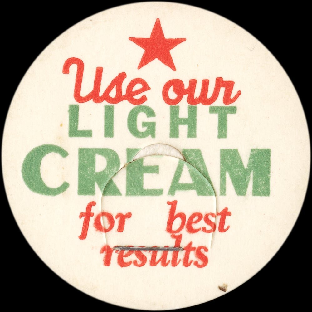Vintage circular dairy cap with printed typographic milk advertising and a metal pull tab.