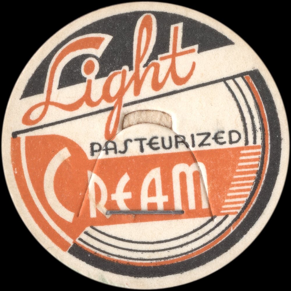 Vintage circular dairy cap with printed typographic milk advertising and a metal pull tab.