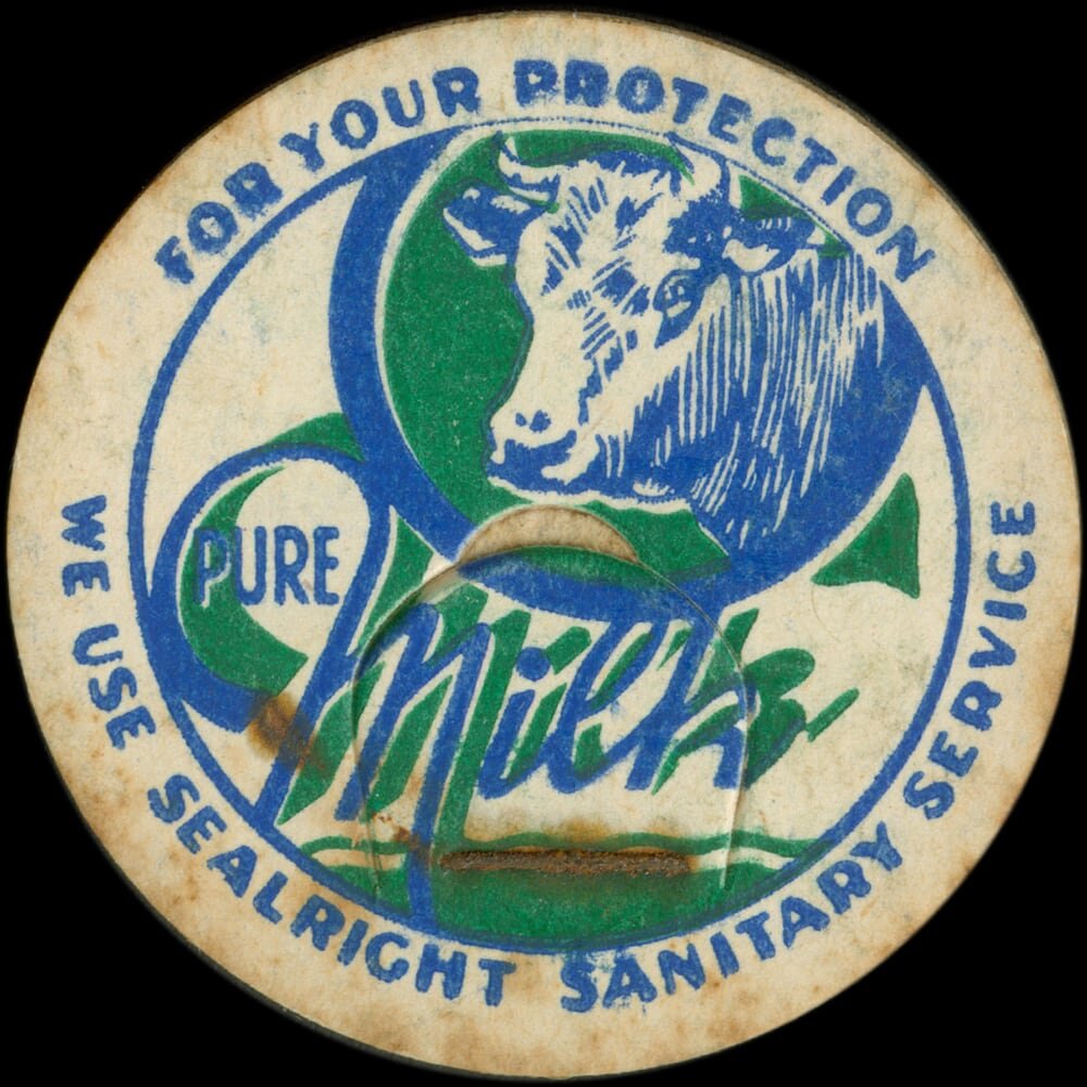 Vintage circular dairy cap with printed typographic milk advertising and a metal pull tab.
