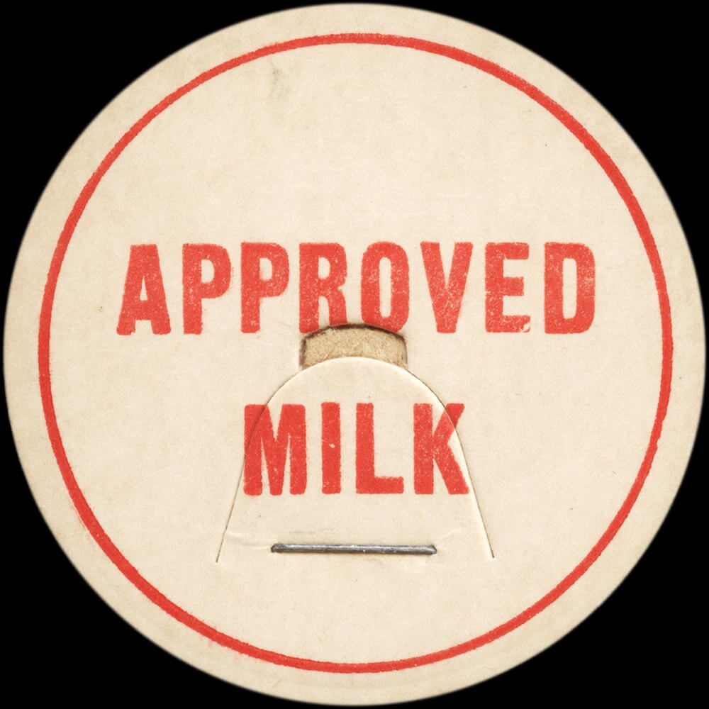 Vintage circular dairy cap with printed typographic milk advertising and a metal pull tab.