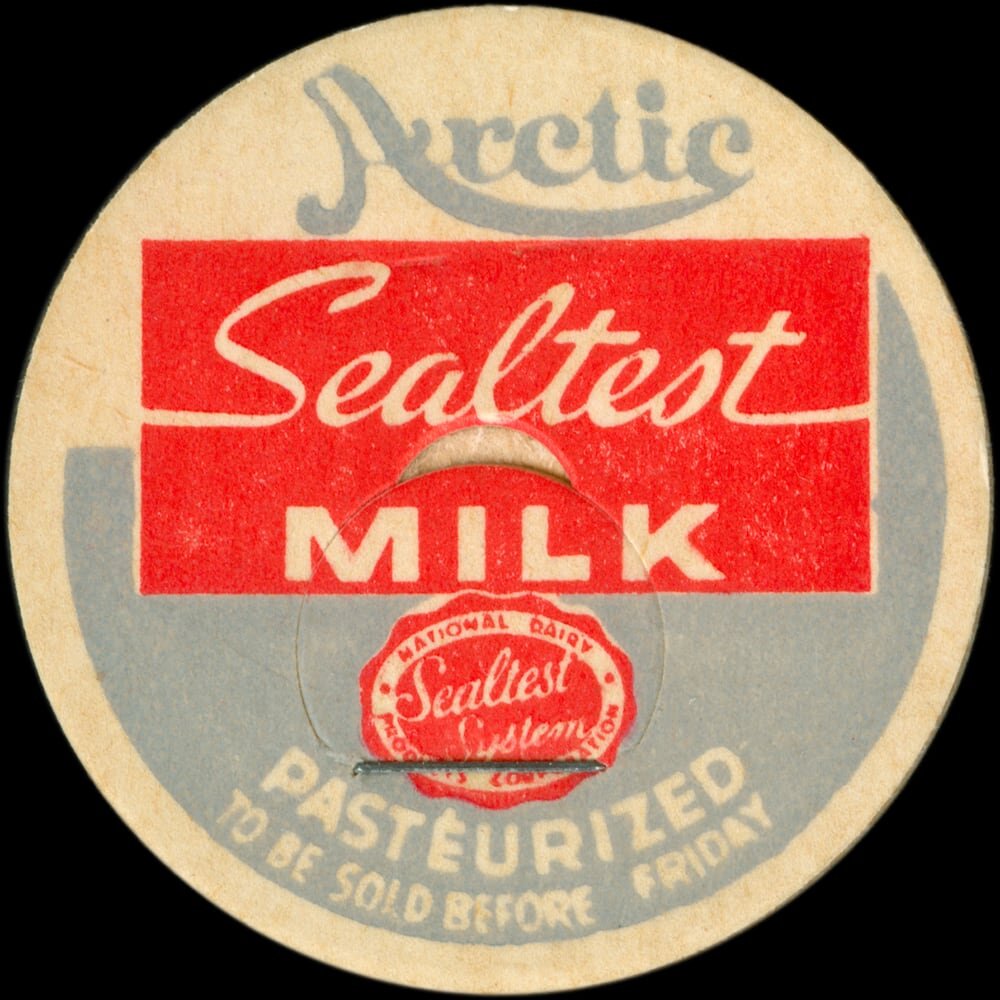 Vintage circular dairy cap with printed typographic milk advertising and a metal pull tab.