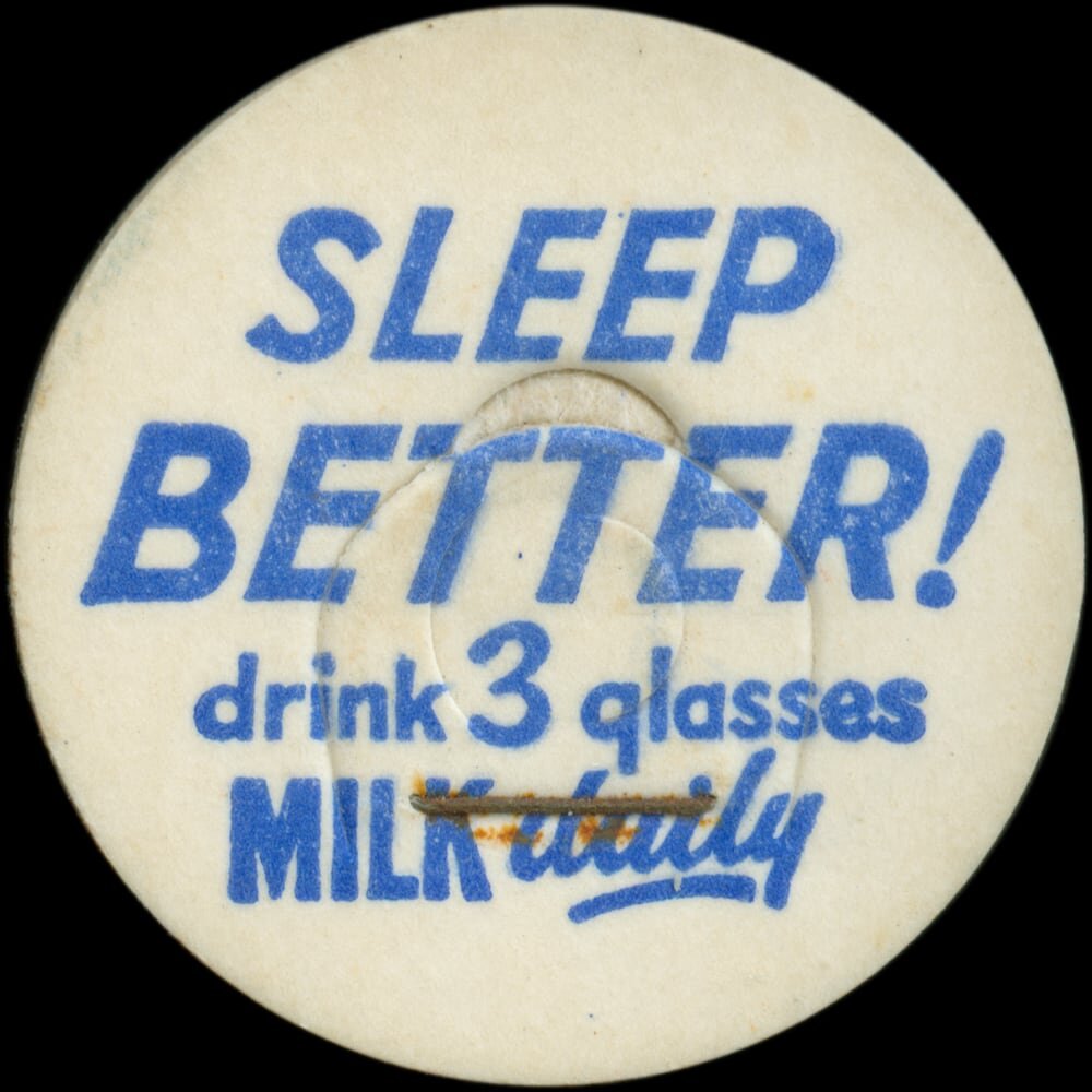 Vintage circular dairy cap with printed typographic milk advertising and a metal pull tab.