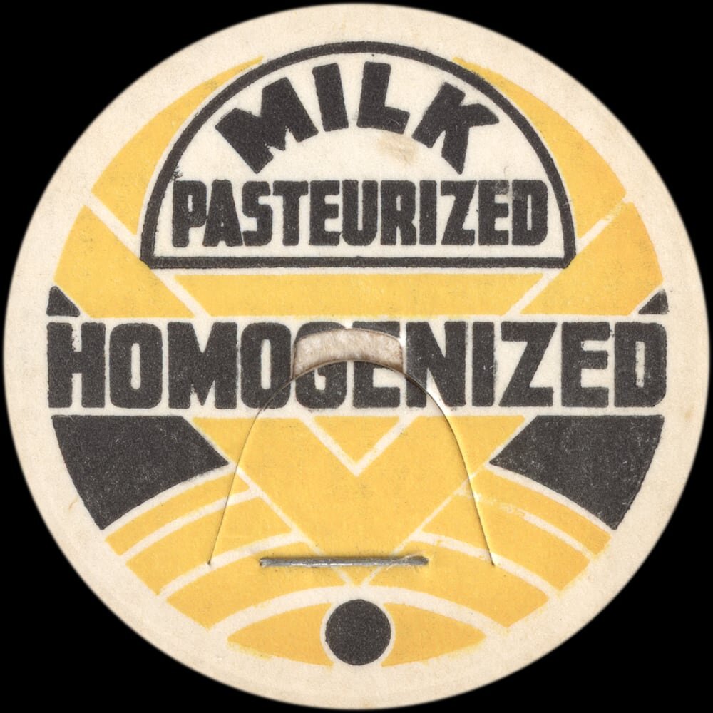 Vintage circular dairy cap with printed typographic milk advertising and a metal pull tab.