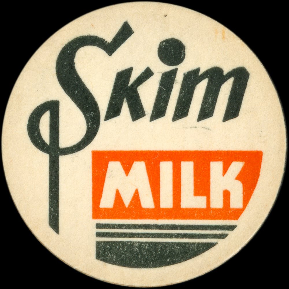 Vintage circular dairy cap with printed typographic milk advertising and a metal pull tab.